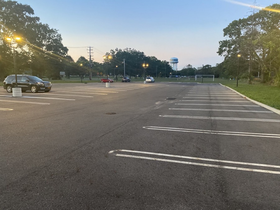Full parking lot with ballfields beyond